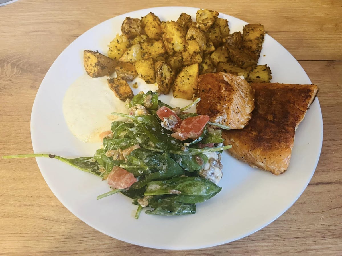 Łosoś z patelni grillowej z pieczonymi ziemniakami, sosem czosnkowym i szpinakiem