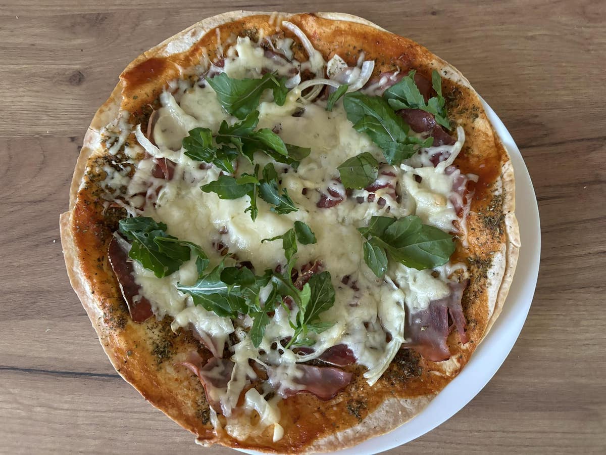 Pizza na tortilli z szynką, serem i rukolą